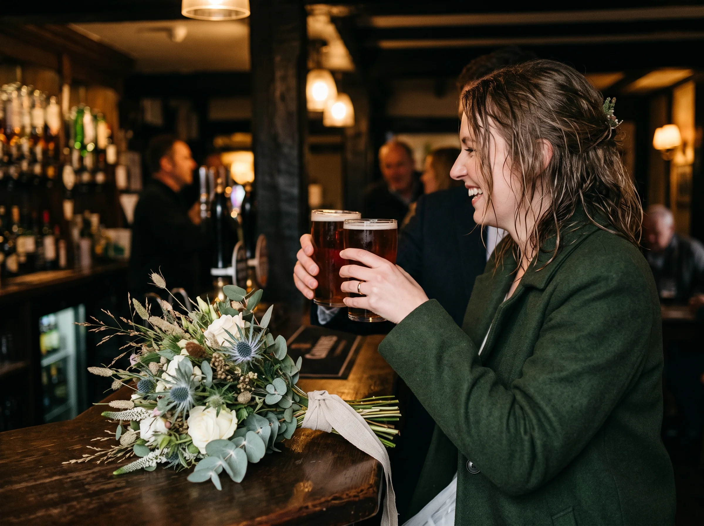 A couple and their guests raise pints at a low-beamed pub bar, hair still wet from the wind, a bouquet lying beside the beer mats